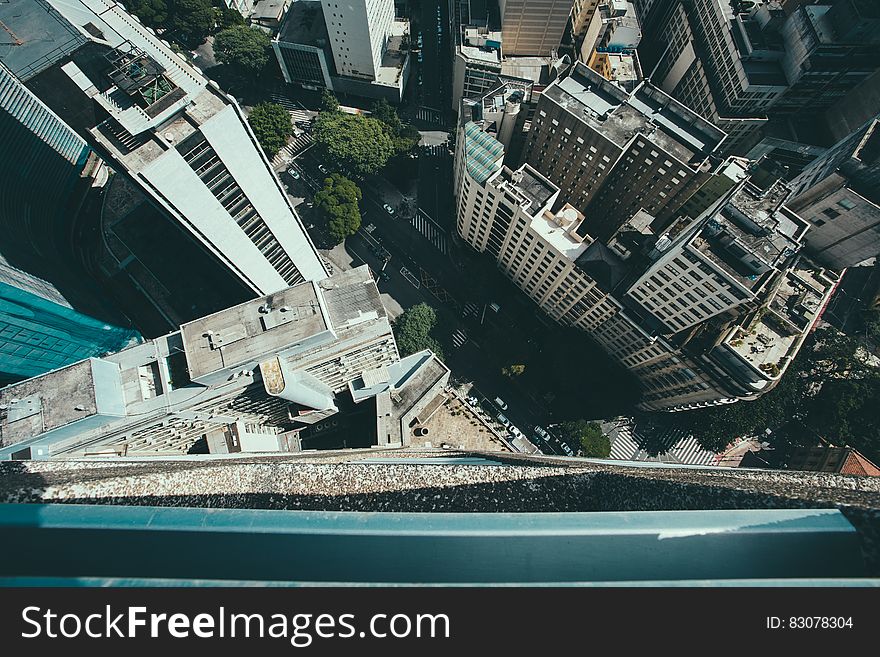 View from the top of a high rise building looking down onto streets and urban architecture.