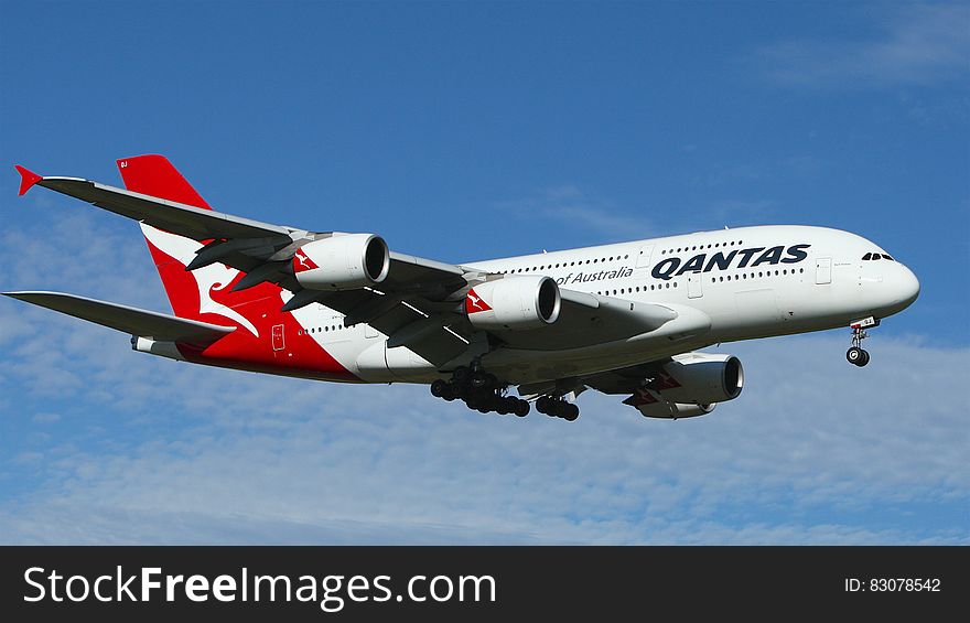 White and Red Qantas Airplane Fly High Under Blue and White Clouds