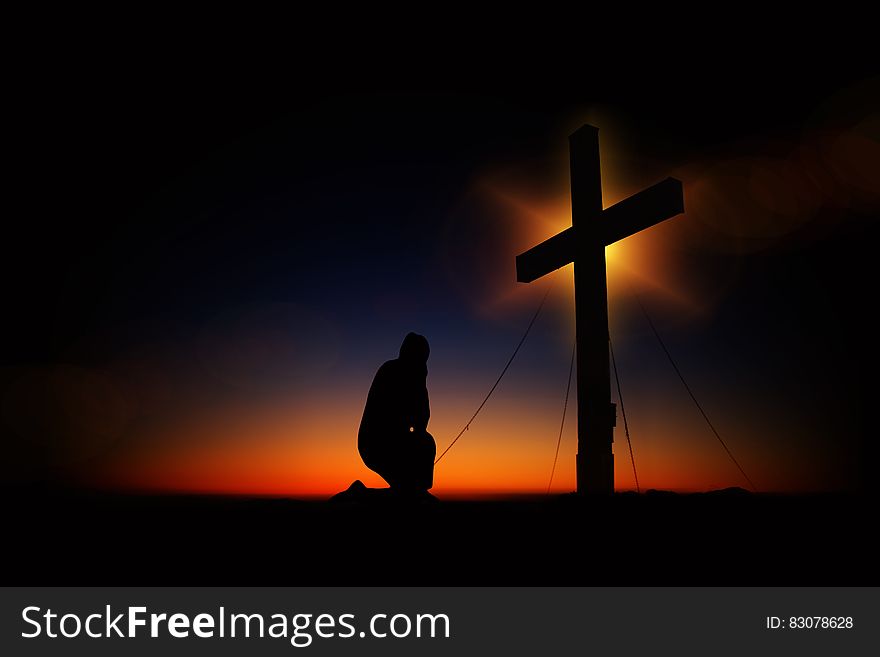 Man Kneeling in Front of Cross