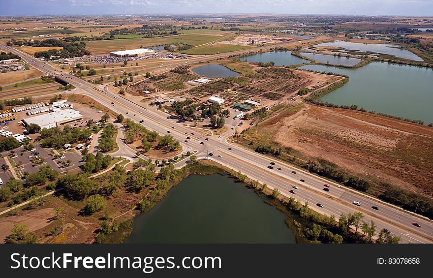Aerial Photography of an Open Road With Cars Near City and Lake during Daytime
