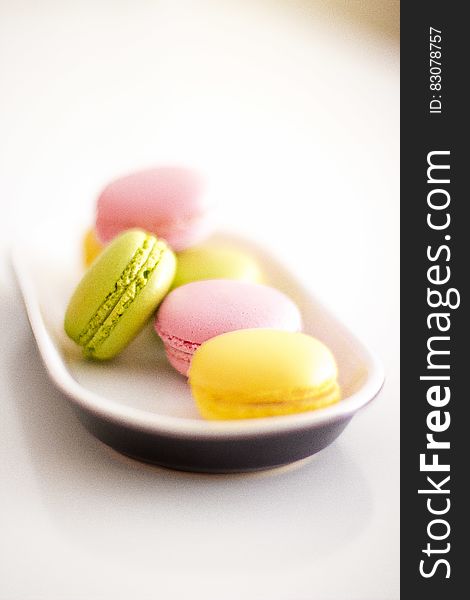 Colorful macaroons on place on white surface.
