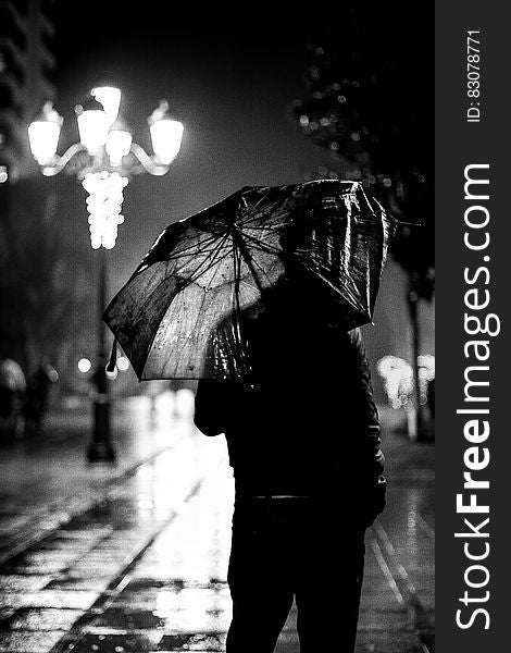 Man with umbrella in a rainy night in the city