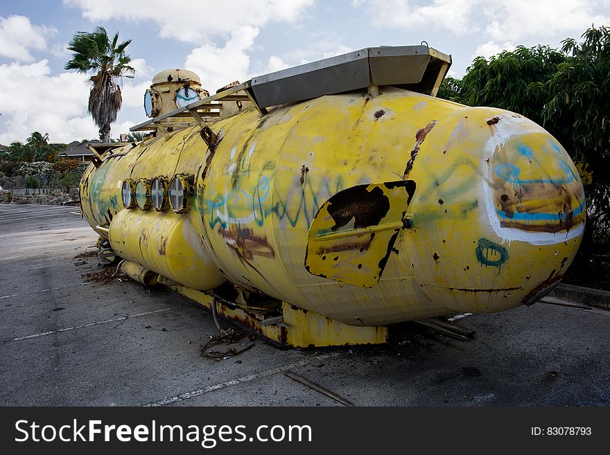 Abandoned yellow submarine displayed on marina.