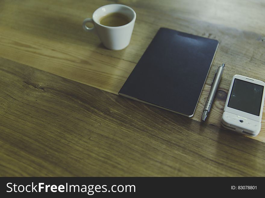 Black Table Computer Beside White Mug