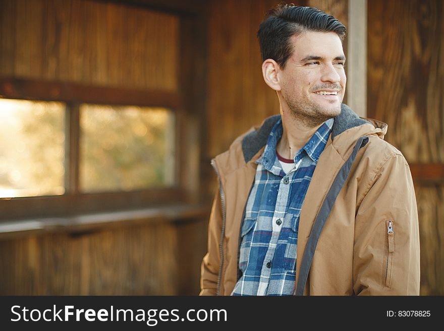 Young man in jacket looking back smiling. Young man in jacket looking back smiling