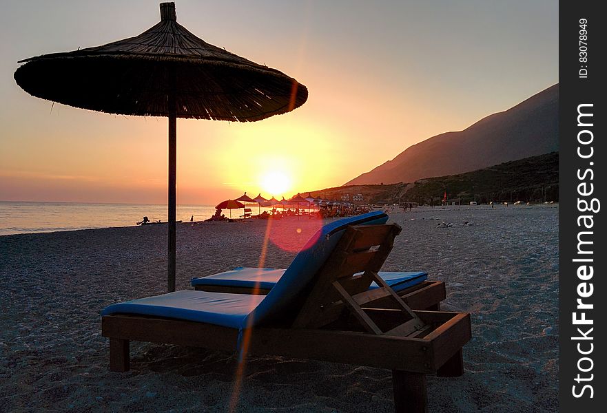 Brown Wooden Lounger On Seashore During Day Time