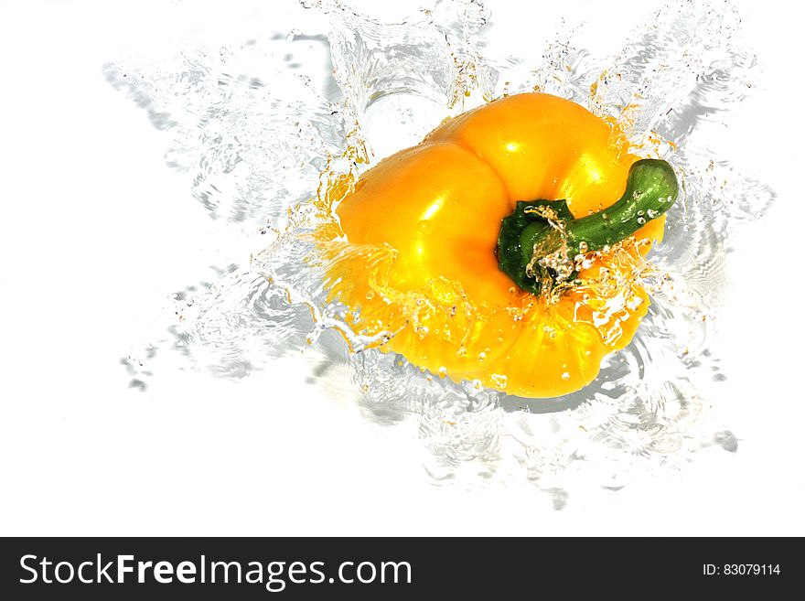 Yellow bell pepper splashing as it drops into water. Yellow bell pepper splashing as it drops into water.