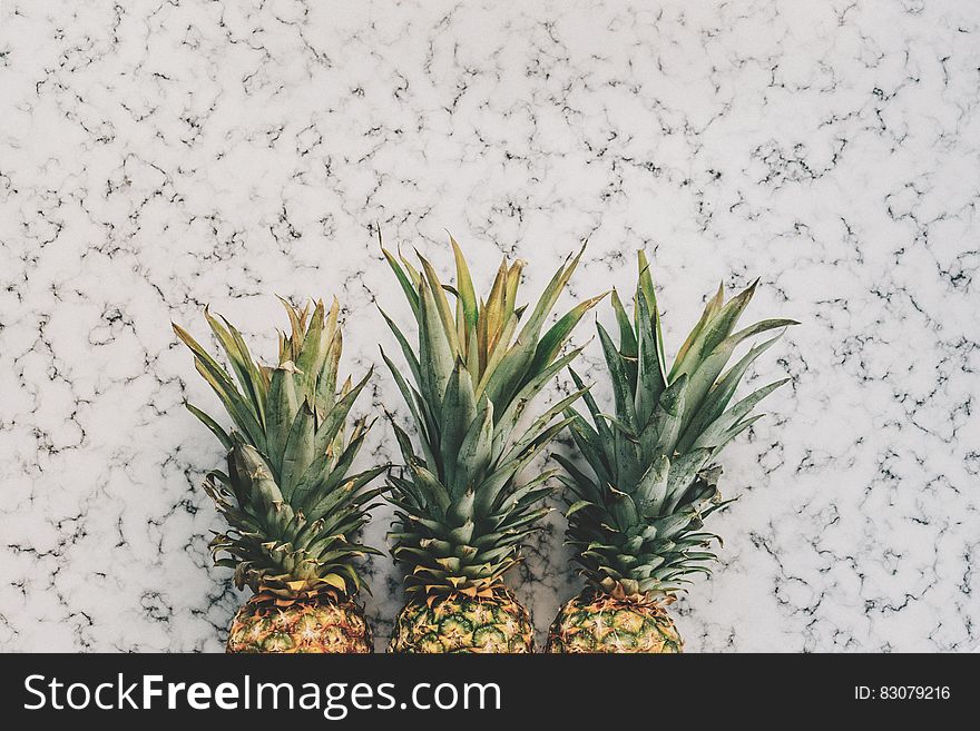 3 Pineapple Fruit On White And Grey Sand