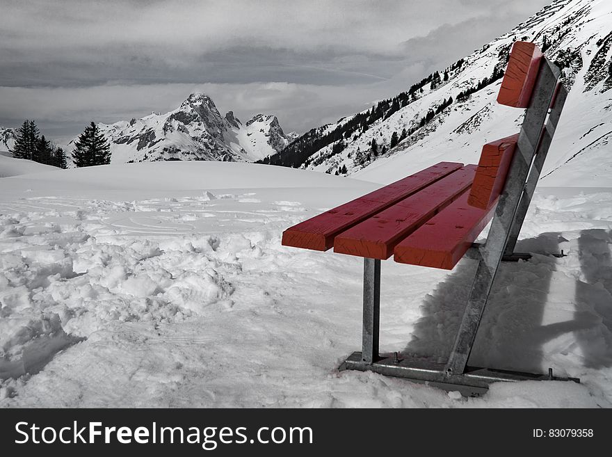 Grey and Brown Bench on Snow Near Mountain during Daytime