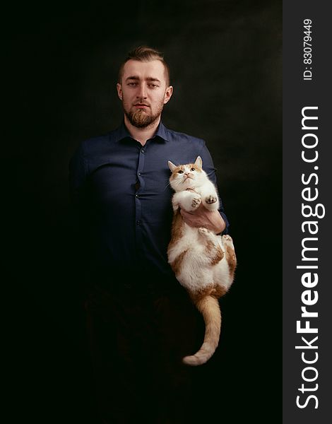 Man in Grey Dress Shirt Holding White and Orange Fur Cat