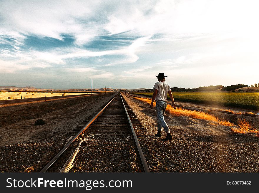 Traveler next to railroad tracks in a travel concept image. Traveler next to railroad tracks in a travel concept image