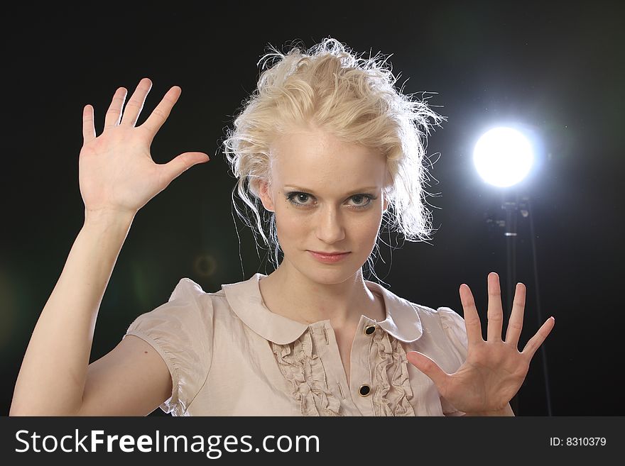 Beautiful blond fashion model posing in studio with backlights. Beautiful blond fashion model posing in studio with backlights