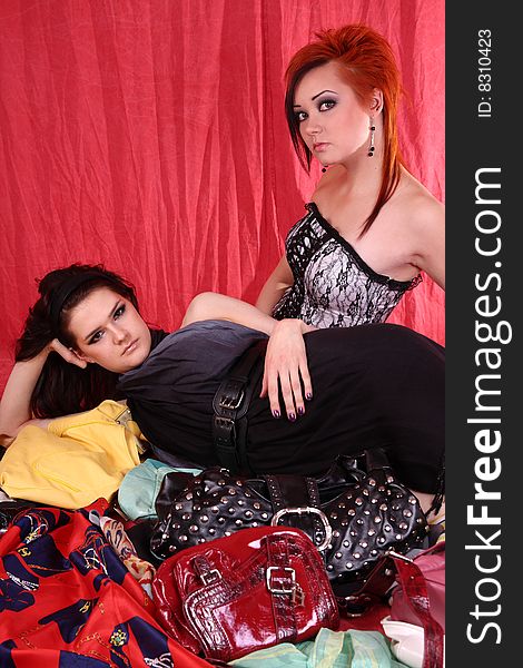 Two models in colorful setting with purses in the studio. Two models in colorful setting with purses in the studio