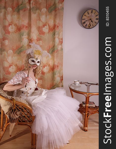 Beautiful model wearing a wedding dress and Venetian mask, studio. Beautiful model wearing a wedding dress and Venetian mask, studio