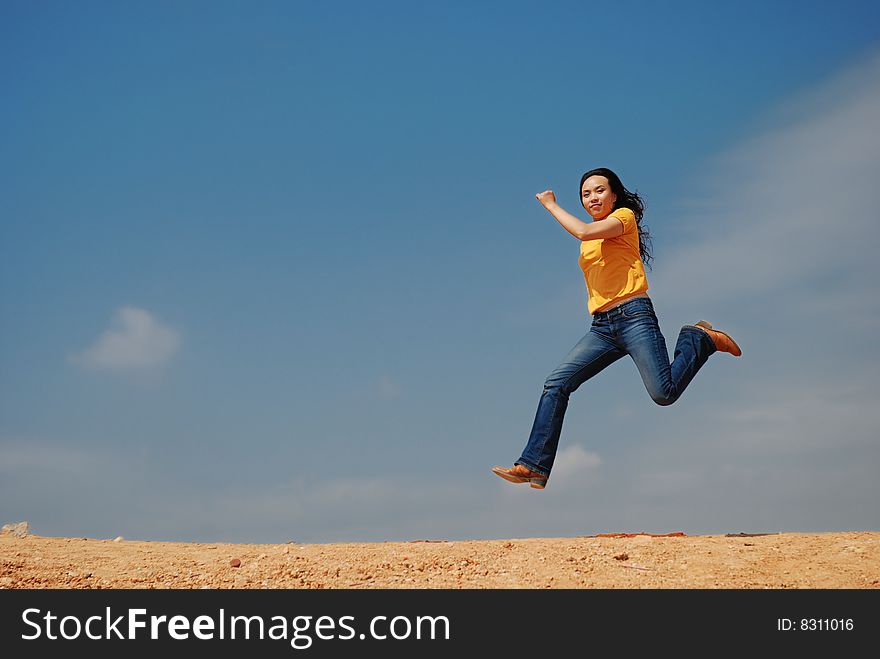 Beautiful Young woman jumping over blue sky