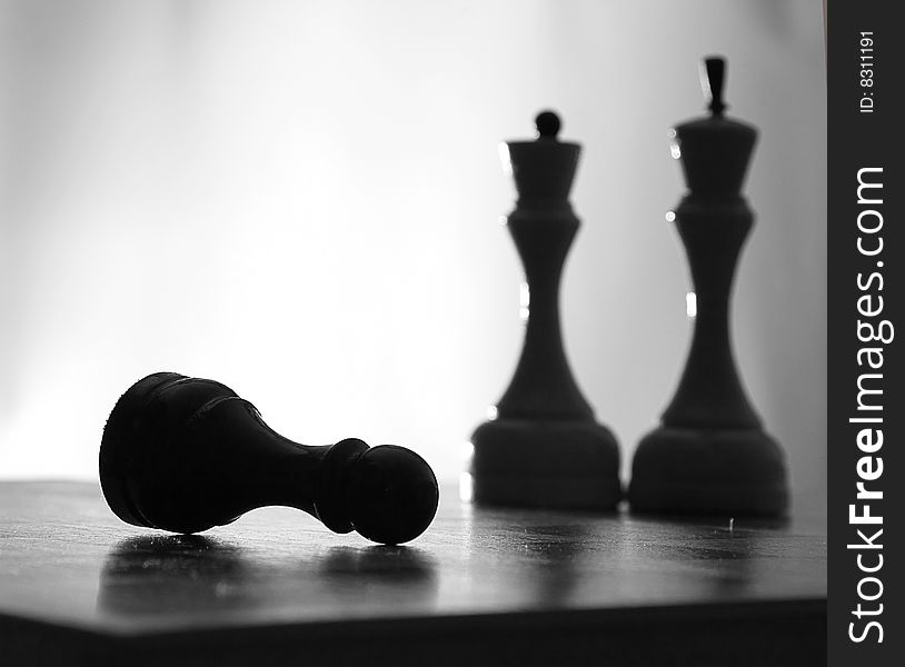 Chessmen, queen, the king, a pawn in a non-standard position on a chessboard. Chessmen, queen, the king, a pawn in a non-standard position on a chessboard