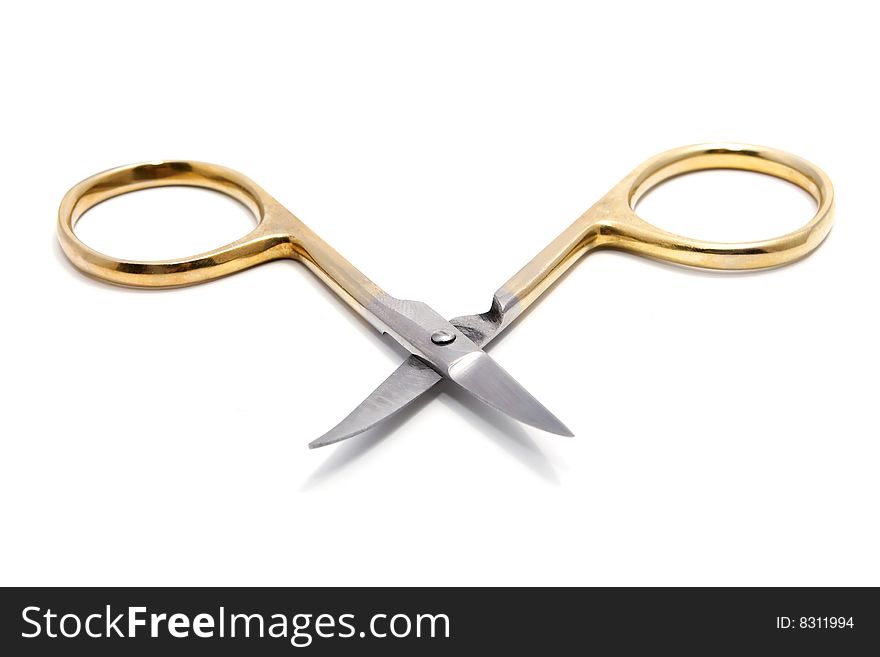 Old golden manicure scissors isolated on white background with shadows