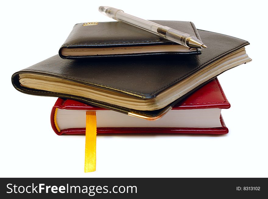 Three notebooks (organizers) and jell pen on isolated background. Three notebooks (organizers) and jell pen on isolated background.