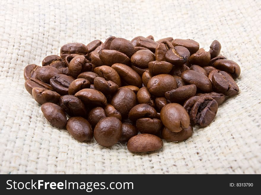 Heap of coffee beans on a brown canvas. Heap of coffee beans on a brown canvas