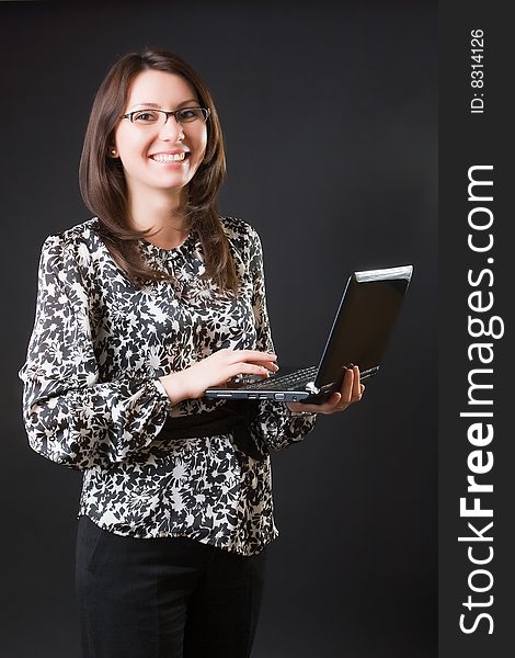 Business woman with a mobile computer against a dark background. Business woman with a mobile computer against a dark background