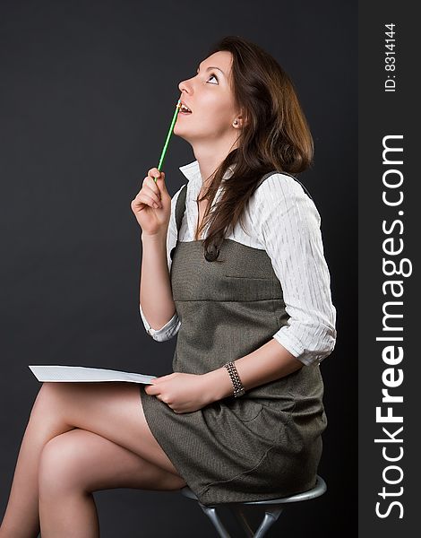 Pensive woman with a notebook against a dark background. Pensive woman with a notebook against a dark background