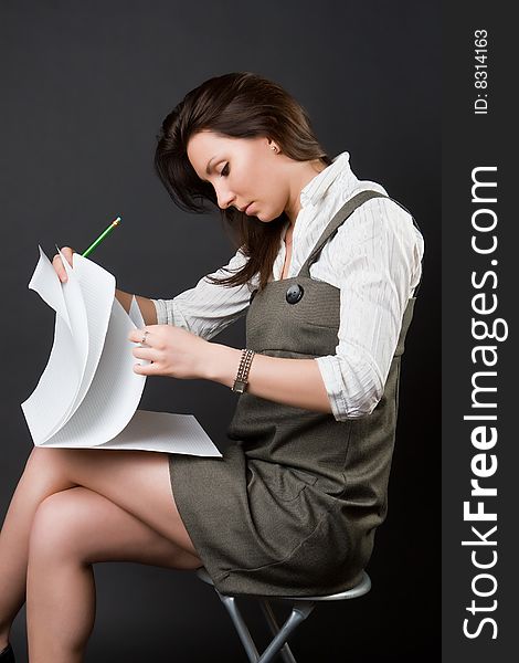 Pensive woman with a notebook against a dark background. Pensive woman with a notebook against a dark background