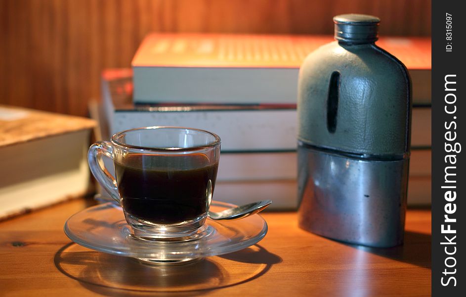 A cup of black coffee with whisky hipflask