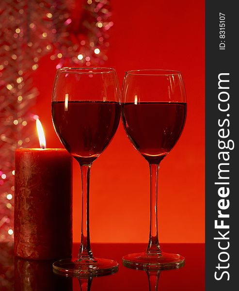 Two glasses of red wine on a red background