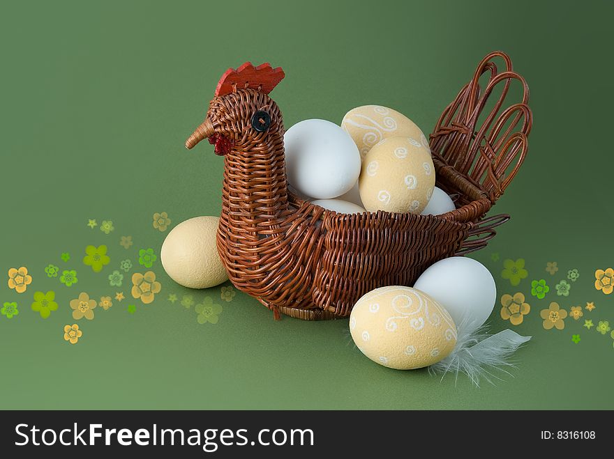Easter eggs with basket on green background