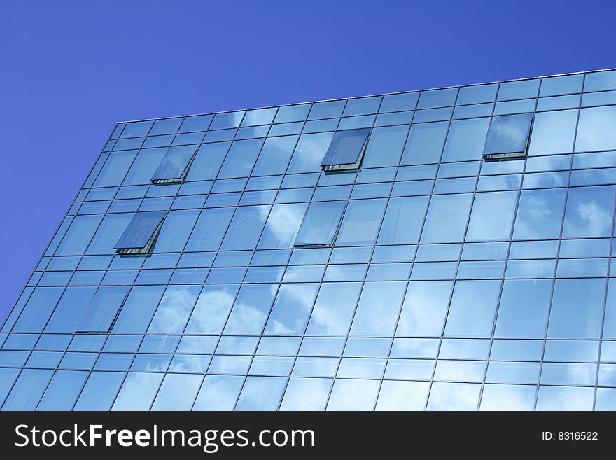 Modern glass office building of dark blue colour. Modern glass office building of dark blue colour