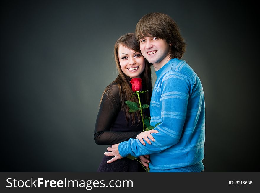 Cheerful couple with rose, studio shot