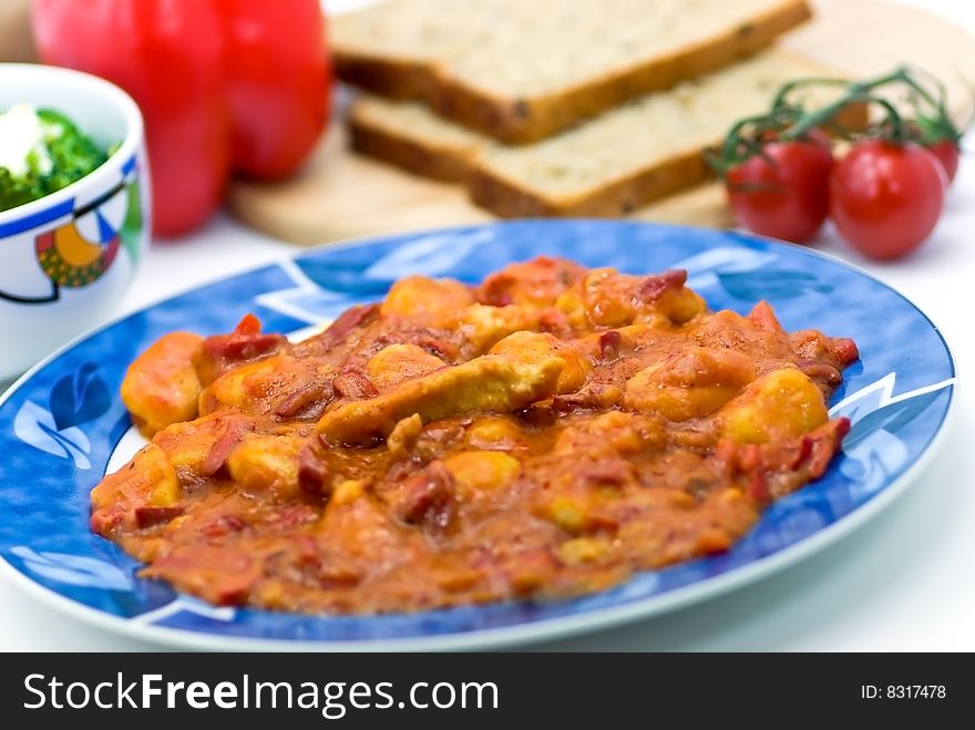 Slice of meat with dumplings-Gnocchi- and red bell pepper  sauce.