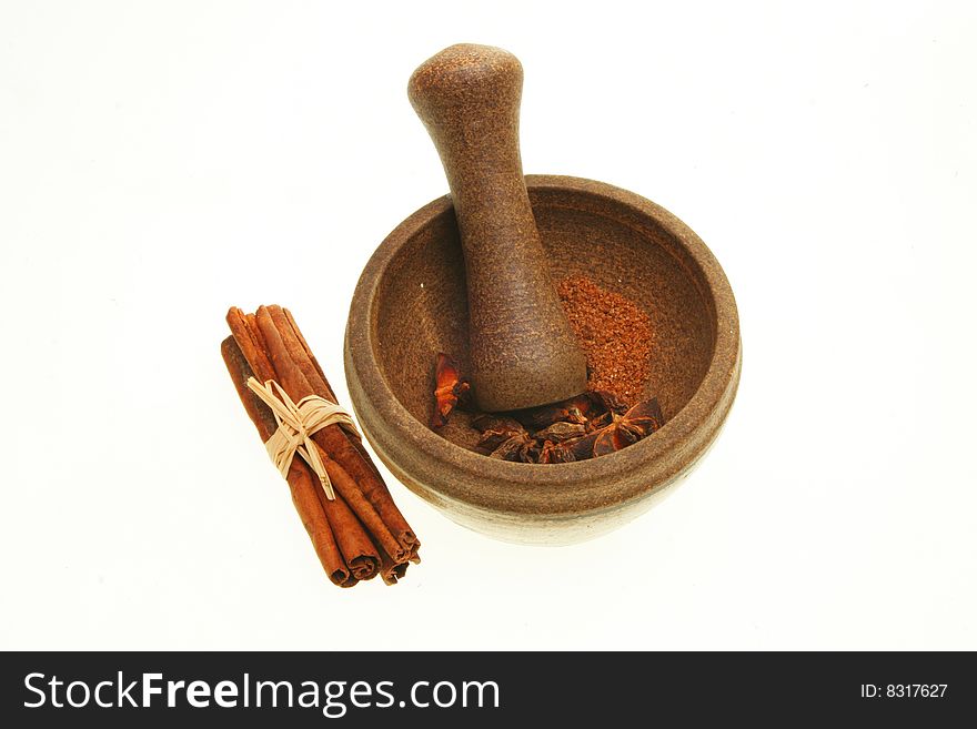 Pestle and mortar with spices isolated on white