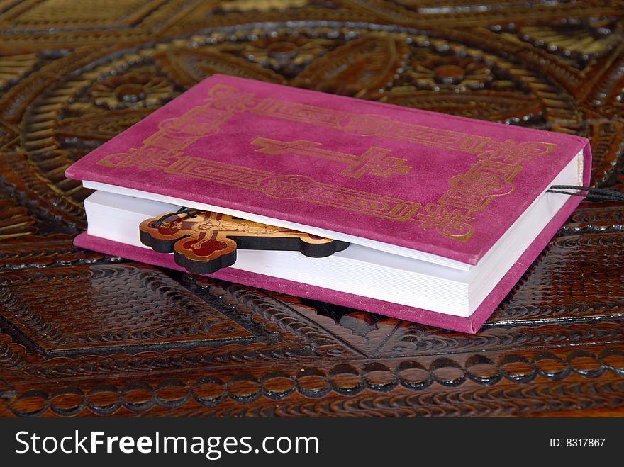 Red Bible book with wooden cross on table. Red Bible book with wooden cross on table