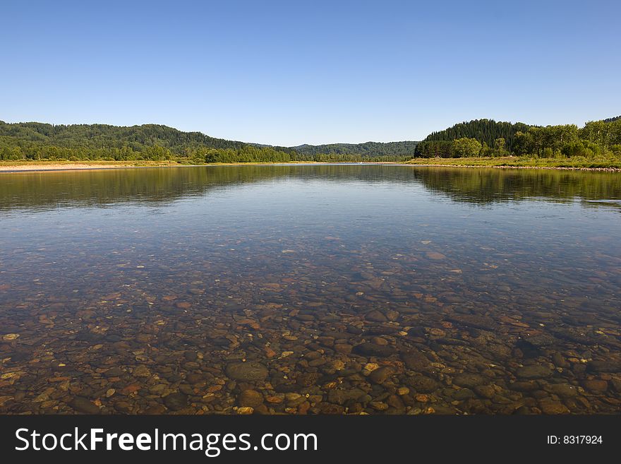 Blue river with pebbles landscape