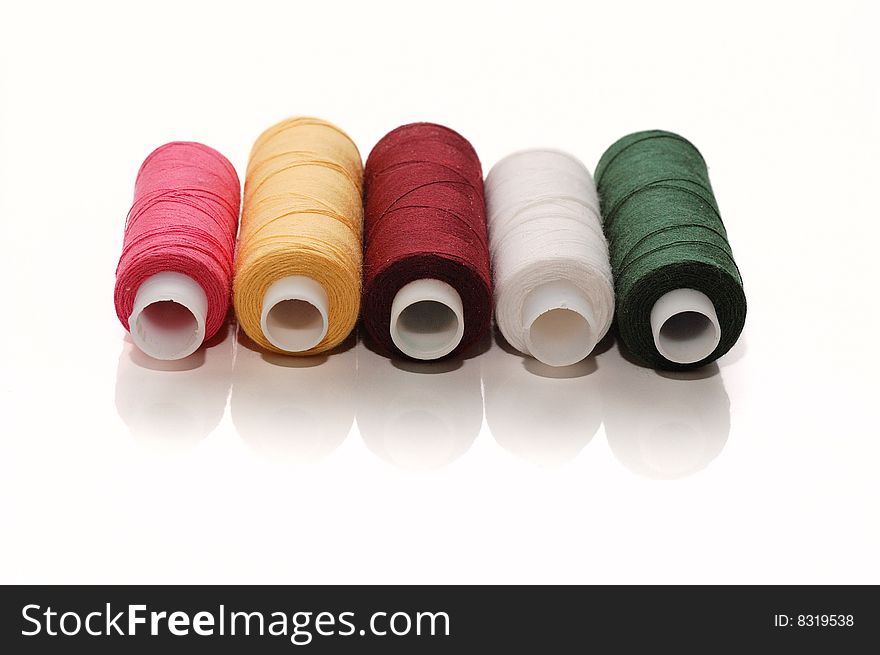 Five colourful spool of sewing threads. Isolated