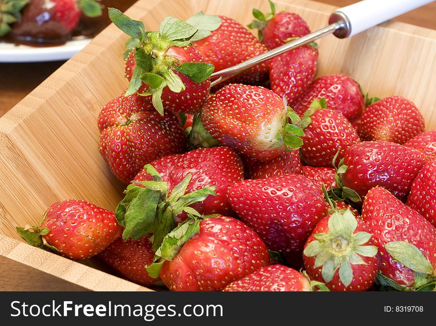Fresh juicy strawberries in a wooden bowl with a serving utensil  copy space