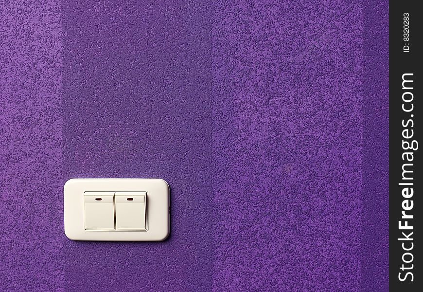 Electric switch on the lilac wall