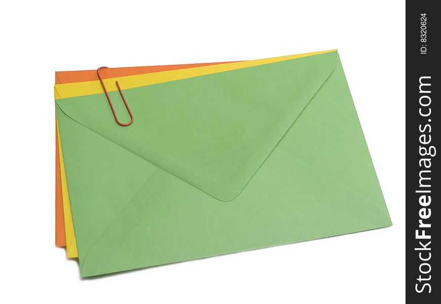 Green, yellow and orange envelopes with paper clip. Green, yellow and orange envelopes with paper clip