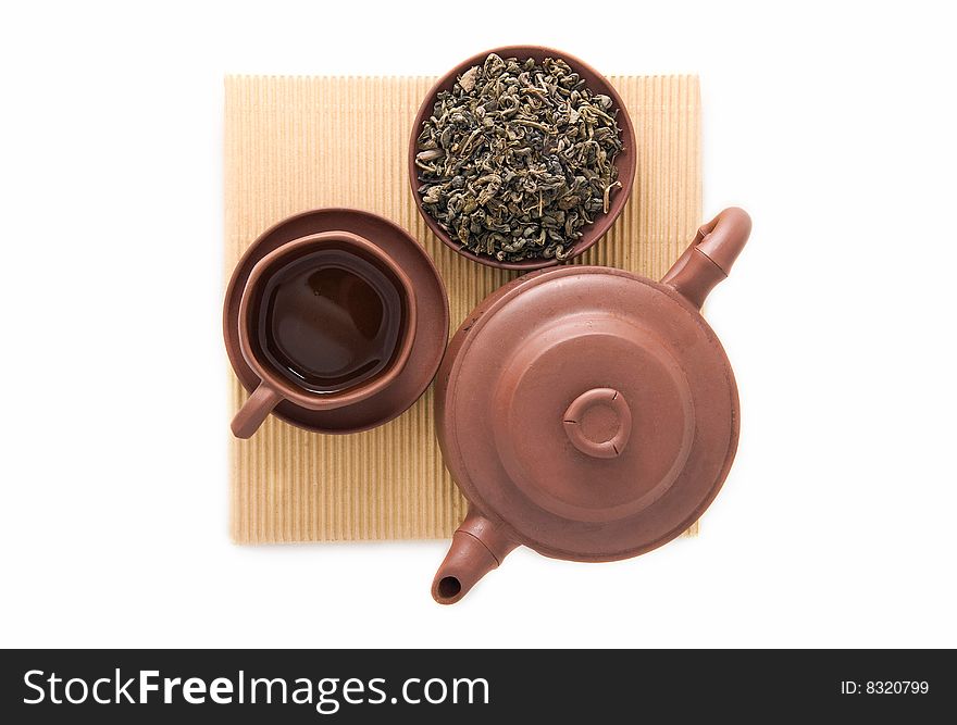 Teapot cup and bowl of green tea leaves isolated. Teapot cup and bowl of green tea leaves isolated