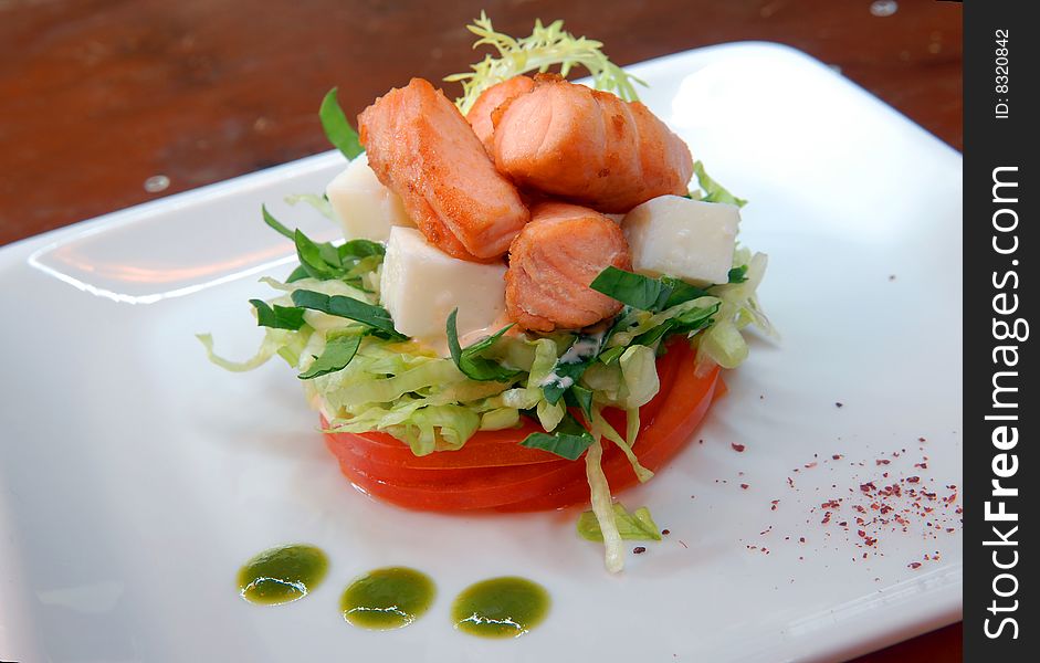 Salad from fresh vegetables with cheese and pieces of salmon. Salad from fresh vegetables with cheese and pieces of salmon
