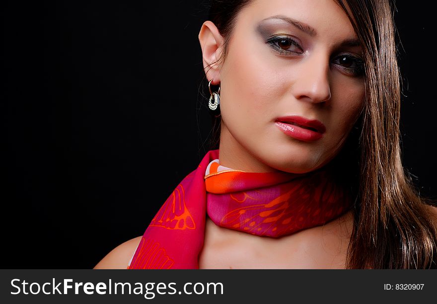 Beautiful brunet woman in red scarf at black background. Beautiful brunet woman in red scarf at black background