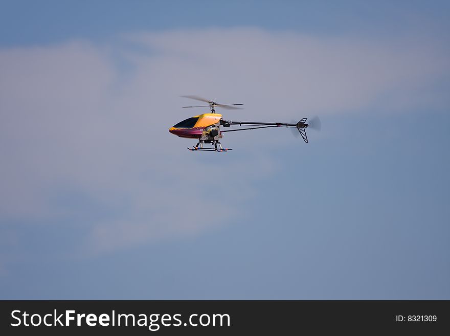 An R/C model helicopter in flight across the airfield. An R/C model helicopter in flight across the airfield