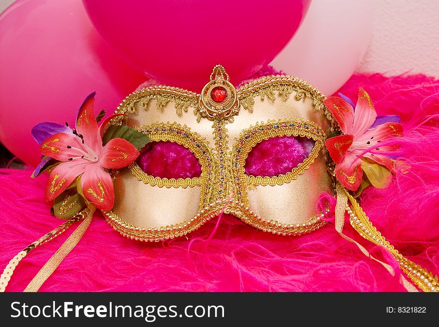 Golden mask with flowers and pink fluffy fur and balloons