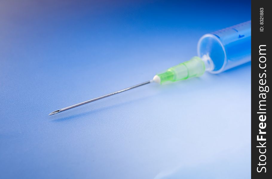 Empty syringe on blue background