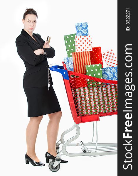 A smartly dressed woman shopping for gifts with a credit card and shopping cart on white. A smartly dressed woman shopping for gifts with a credit card and shopping cart on white.