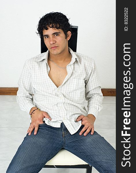 Teenager latino boy seated posing to the camera. Teenager latino boy seated posing to the camera