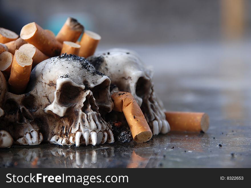 Ashtray made of tiny skulls, filled with cigarette butts and ashes