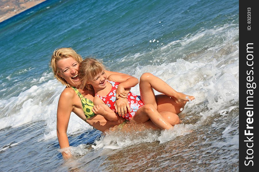 Happy mum with a daughter have a rest on the sea