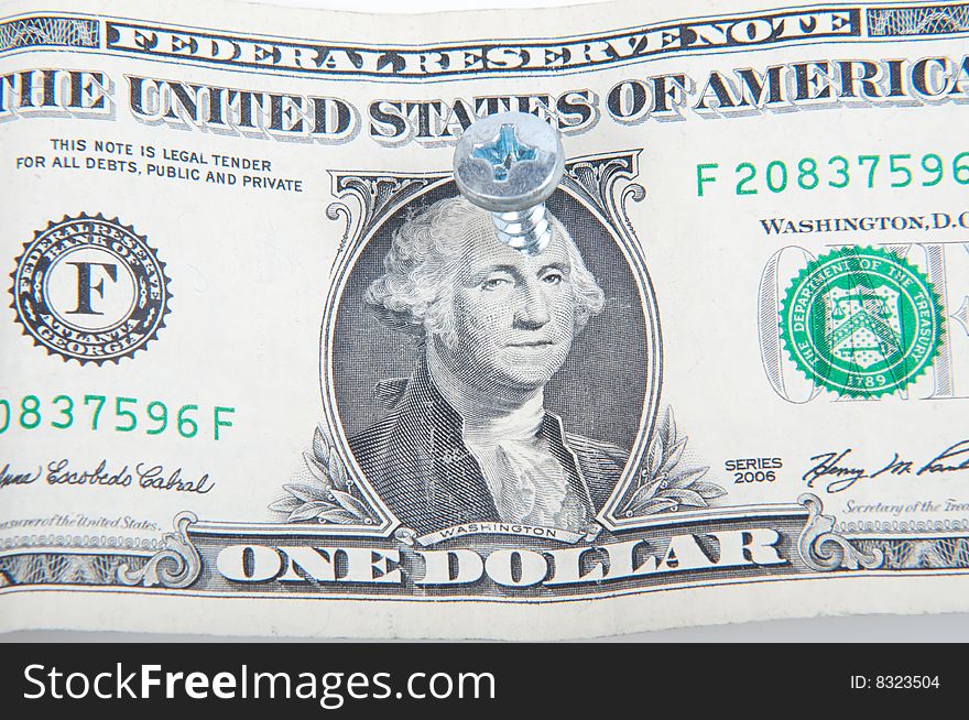 Dollar bill with a screw in the middle of George Washington's head. Dollar bill with a screw in the middle of George Washington's head
